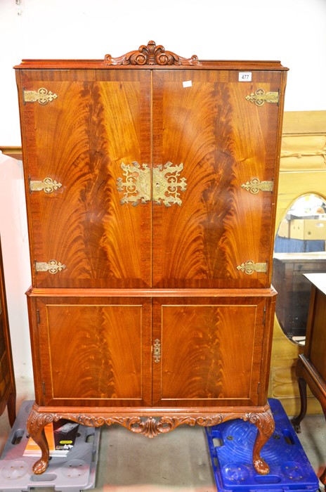 A flamed twin door cocktail cabinet with fittings, above two cupboard doors, with metal mounts