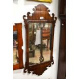A George II mahogany fretwork mirror, shaped scrolling pediment and skirt, glass 50cm x 32cm, overal