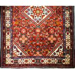 A Caucasian lilian design deep crimson rug, 107cm x 152cm