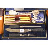 A cased bone handled carving set, two plated berry spoons and assorted flatware