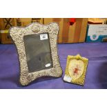 A metal photo frame with foliate border together w