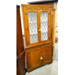 An oak corner cabinet fitted leaded windows. Height 185cm
