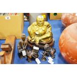 A large brass seated figure of Budda on a wooden s
