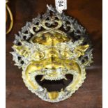 An oriental gilt metal mask modelled as a grotesqu