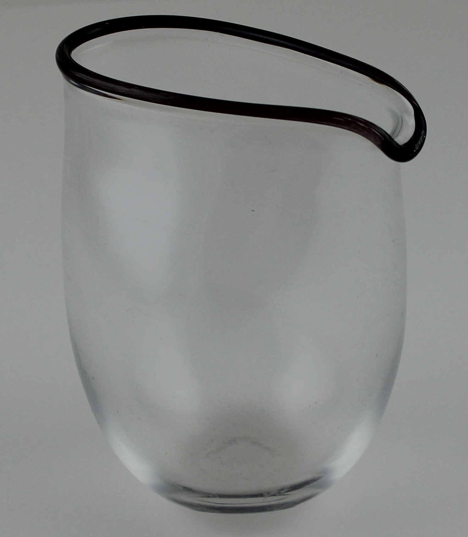 An art glass jug (Simon Moore 1959-Present), having ovaloid shape rim, black/brown rim detail,