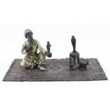 After Franz Bergman, a cold painted Austrian bronze of an Arab seated on carpet, bearing stamp to