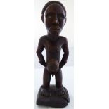 An African tribal Nkisi fetish male ancestor figure with inset glass eyes and possibly magical