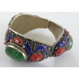 A Chinese silver bracelet with green centralised stones, blue and red enamel, bearing Chinese