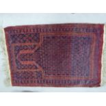 An Afghan rug on a red and navy ground, 87cm x 135cm