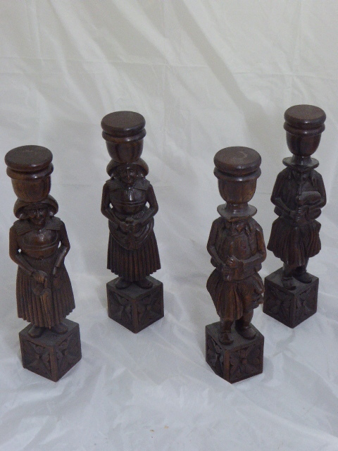 Four oak carved Continental candle holders in the form of figures playing instruments, H.52cm