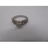 Single diamond ring, flanked with smaller diamonds, 18ct white gold mount.
