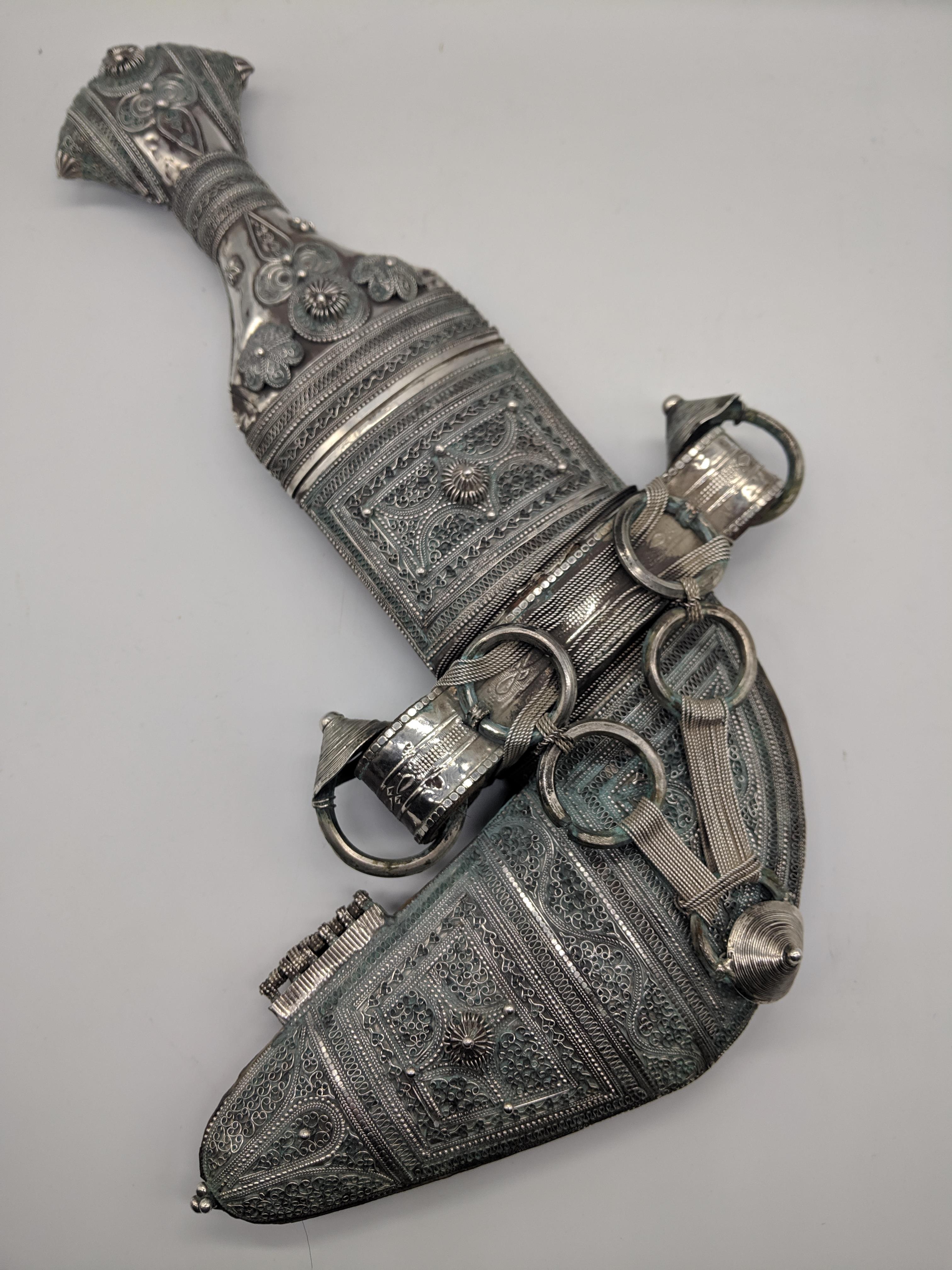 A silver Middle Eastern Khanjar dagger, filigree decor with leather back