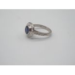 Single Sapphire ring flanked with small diamonds, mounted on 18ct white gold.