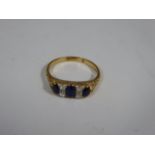 An 18ct yellow gold ring, three sapphires, four small diamonds, 3.1g,
