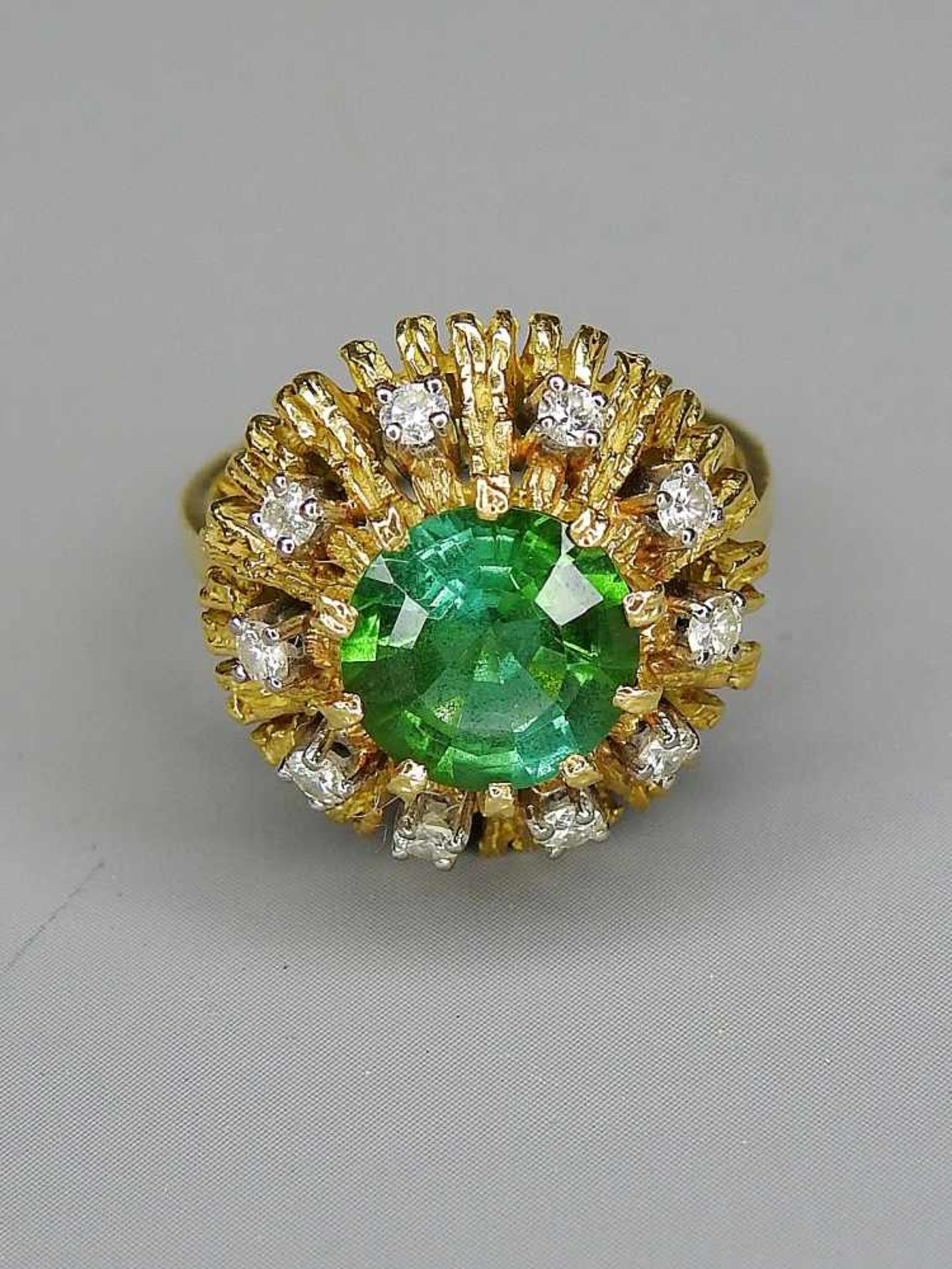 Blumenförmiger Ring mit Smaragd18 K. Gelbgold, mit Smaragdbesatz von ca. 2 ct. und Brillantbesatz