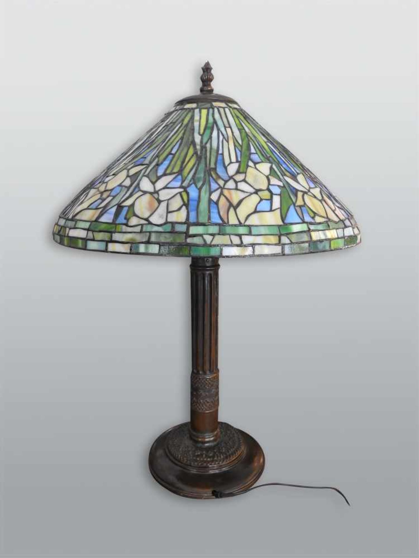 Stehlampe im Design der Tiffany StudiosSockel aus Bronze, Lampenschirm aus Glas und Lötzinn.