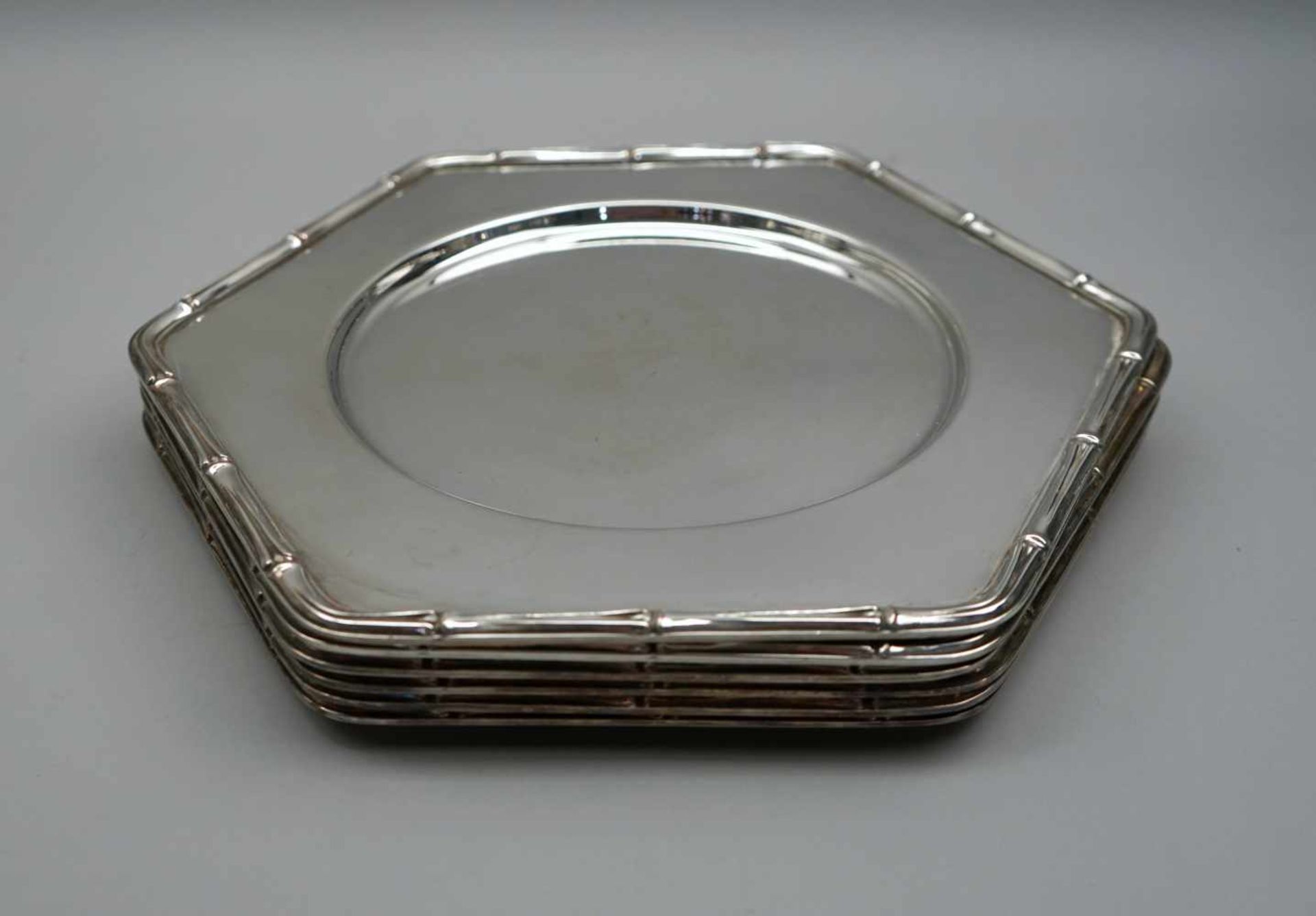 Sechs PlatztellerSilber plated, ungemarkt. Sechs sechseckige Platzteller mit Bordüre in Ast-Optik.