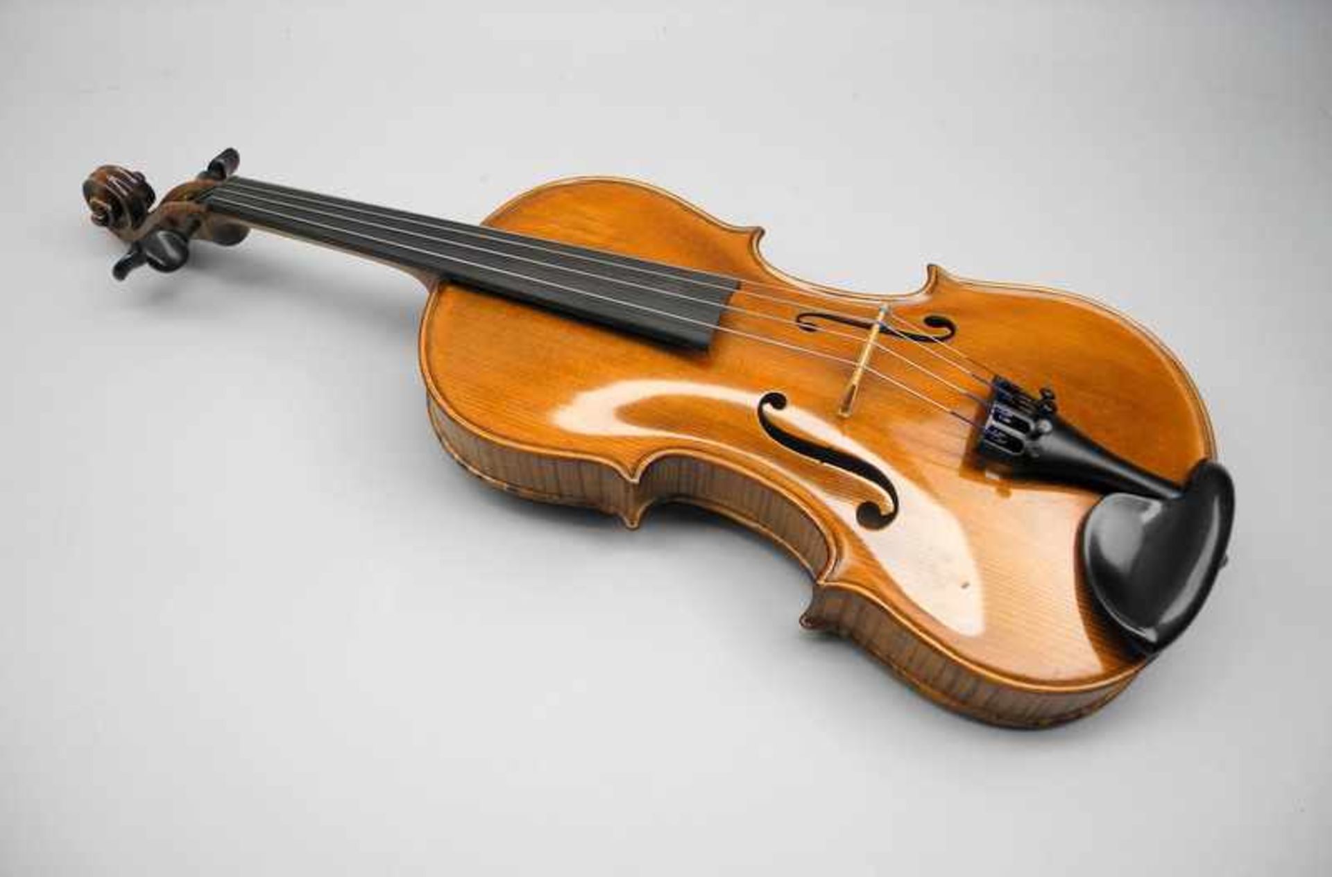 Hochwertige GeigeAus Edelholz. Gebrauchsspuren, Griff abgenutzt, alle Saiten intakt, mit Bogen.