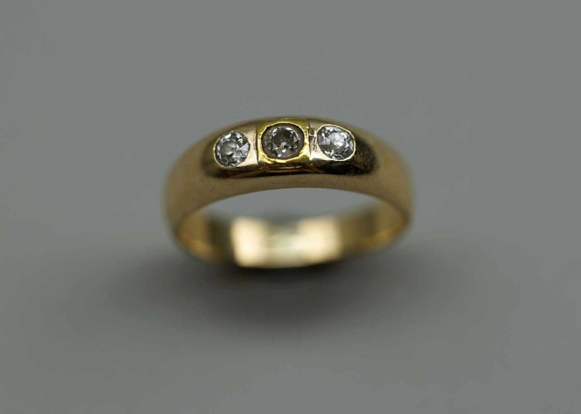 Bandring14 K. Gelbgold (580/1000). Besatz mit drei Brillanten von je 0,05 ct. Altersbedingter