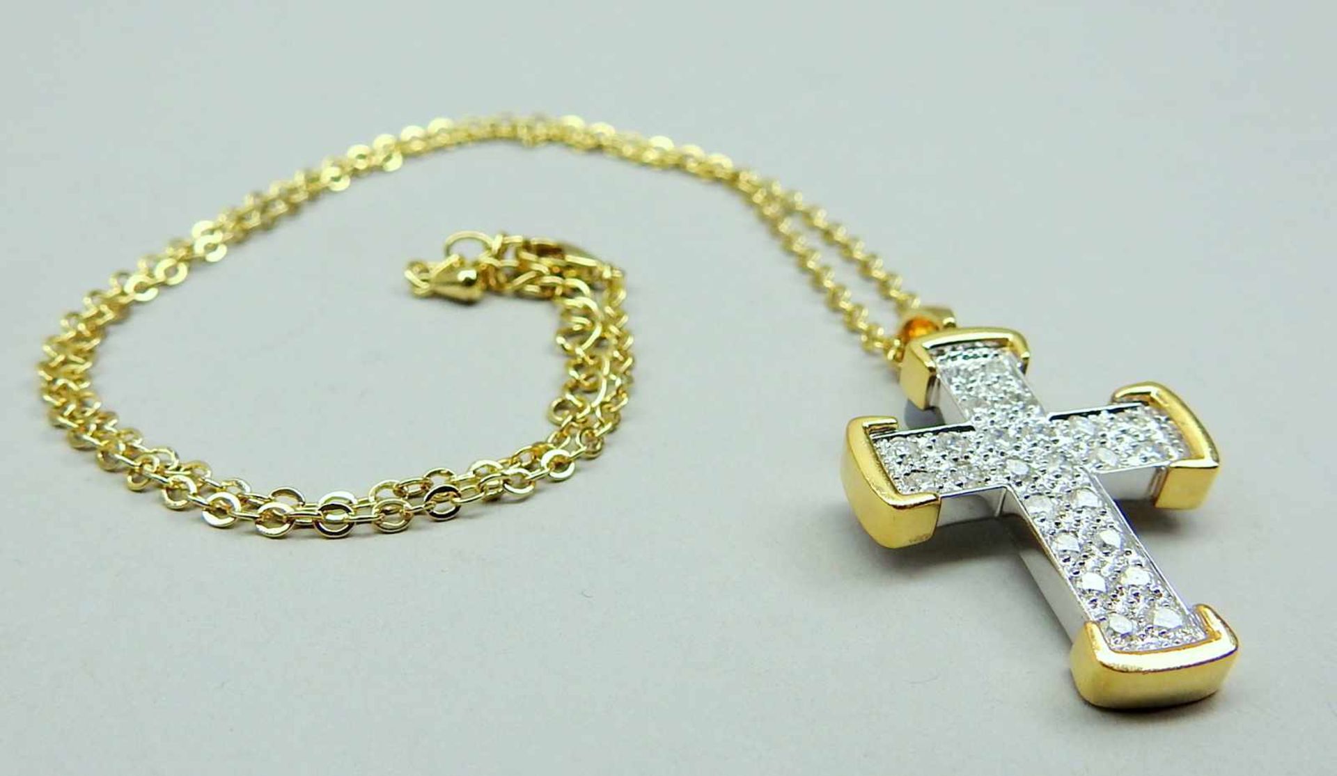 Diamant-Kreuz18 K. bicolor Weißgold/Gelbgold. Goldenes Kreuz besetzt mit Diamanten von insgesamt ca.