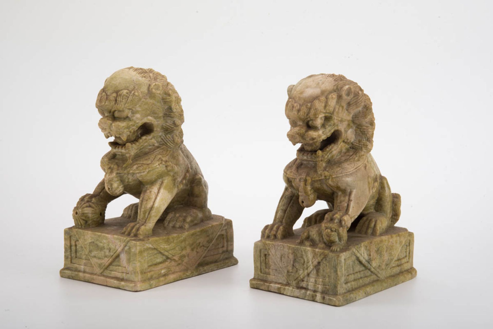 Paar Tempellöwen, ChinaJade geschnitzt. Auf rechteckigem Sockel wird der weibliche Löwe mit einem