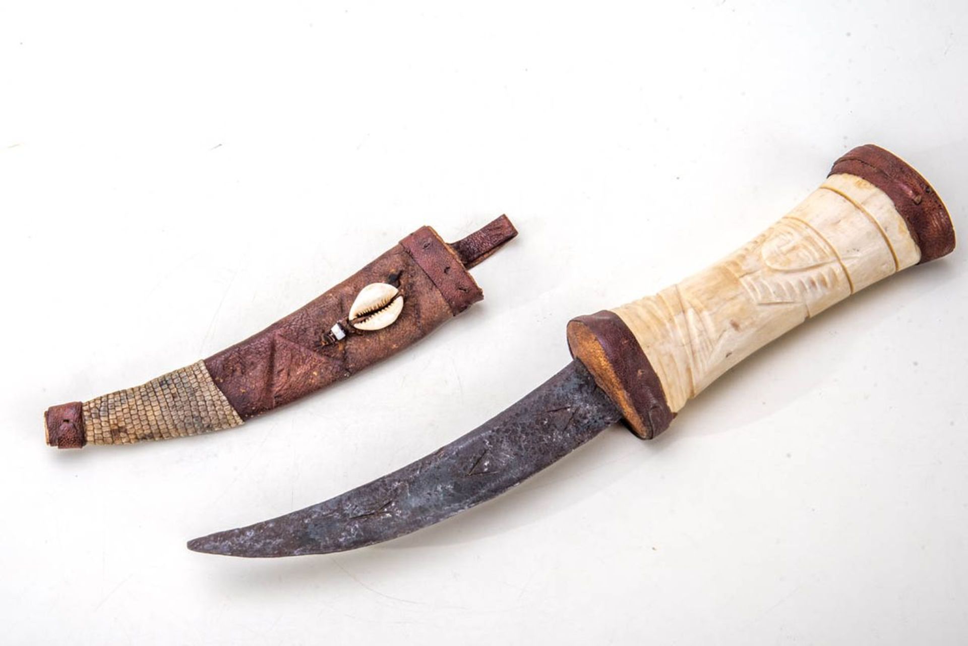 Krummdolch, AfrikaSäbel mit gekrümmter Klinge, graviert, Lederscheide und geschnitzter Knochengriff.