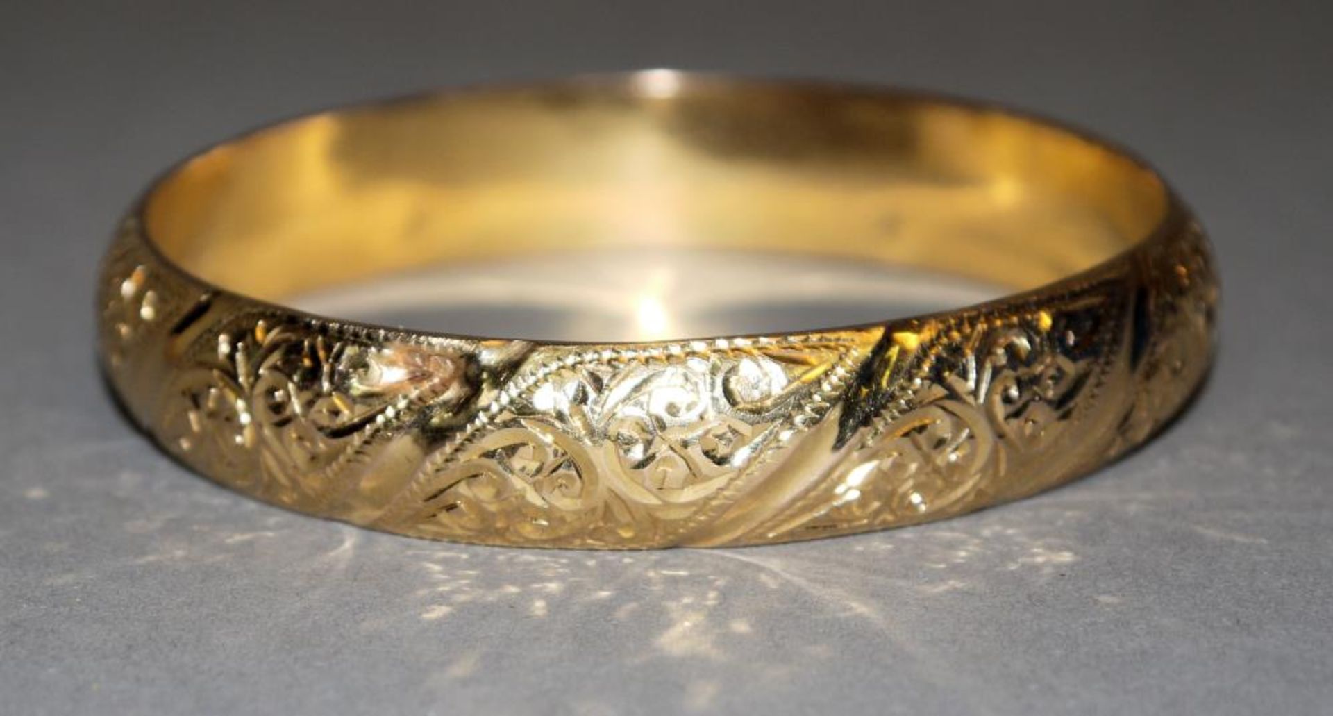 Gold-Armreif 18kt Gelbgold, gepr., 2 ungedeutete Punzen, ziselierter Dekor mit Blumen, wohl