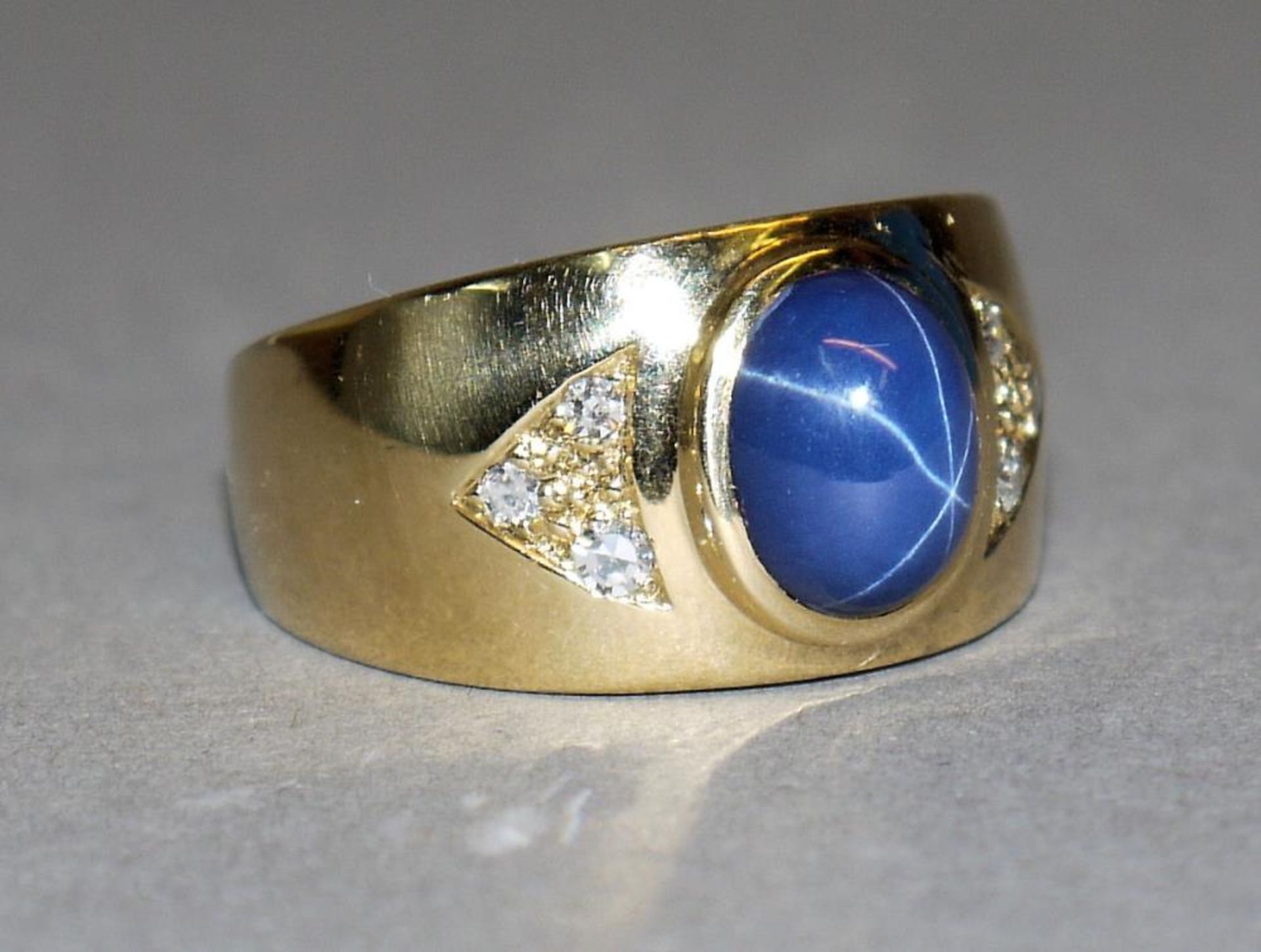 Schwerer Bandring mit Sternsaphir und Diamanten, Gold 18kt Gelbgold, besetzt mit einem ovalen blauen