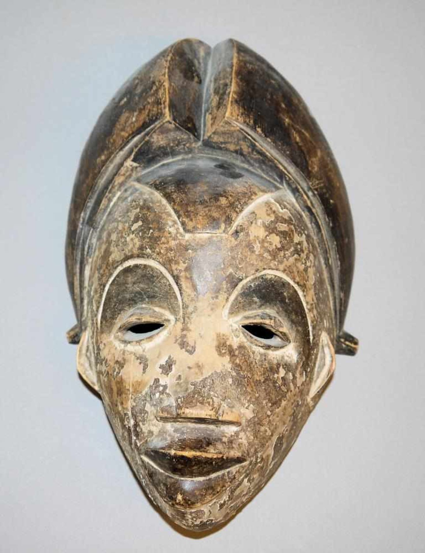 Maske der Punu, Gabun Maskengesicht mit hohem, mittig geteiltem Kopfputz, die Gesichtsfläche mit