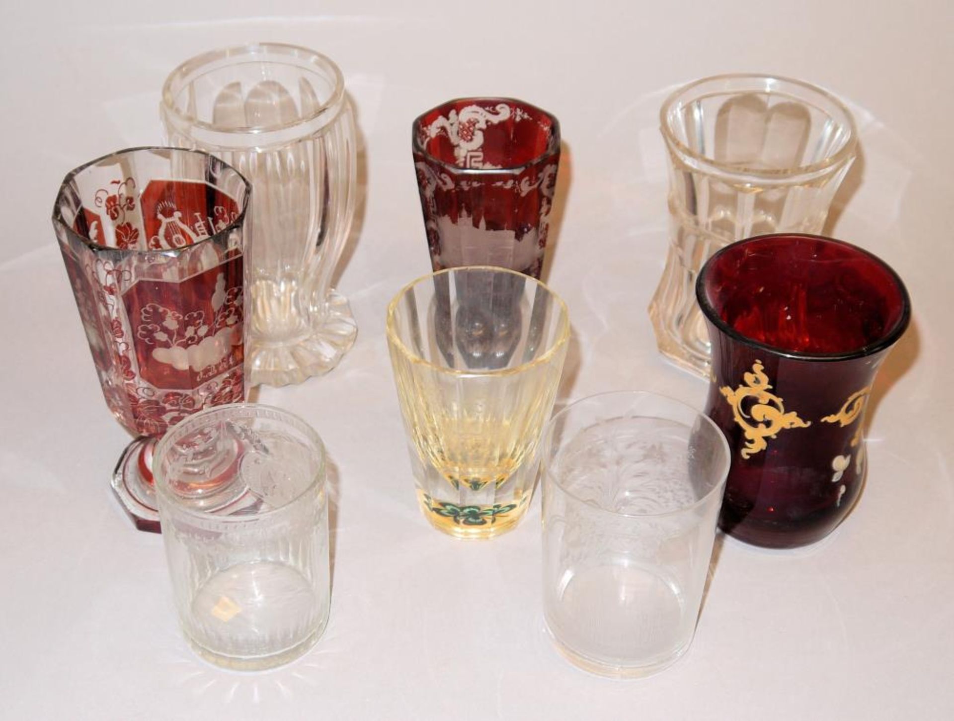 Acht Becher und Andenkenbecher aus Glas, 19. Jh. Konischer, facettierter Becher aus farblosem Glas