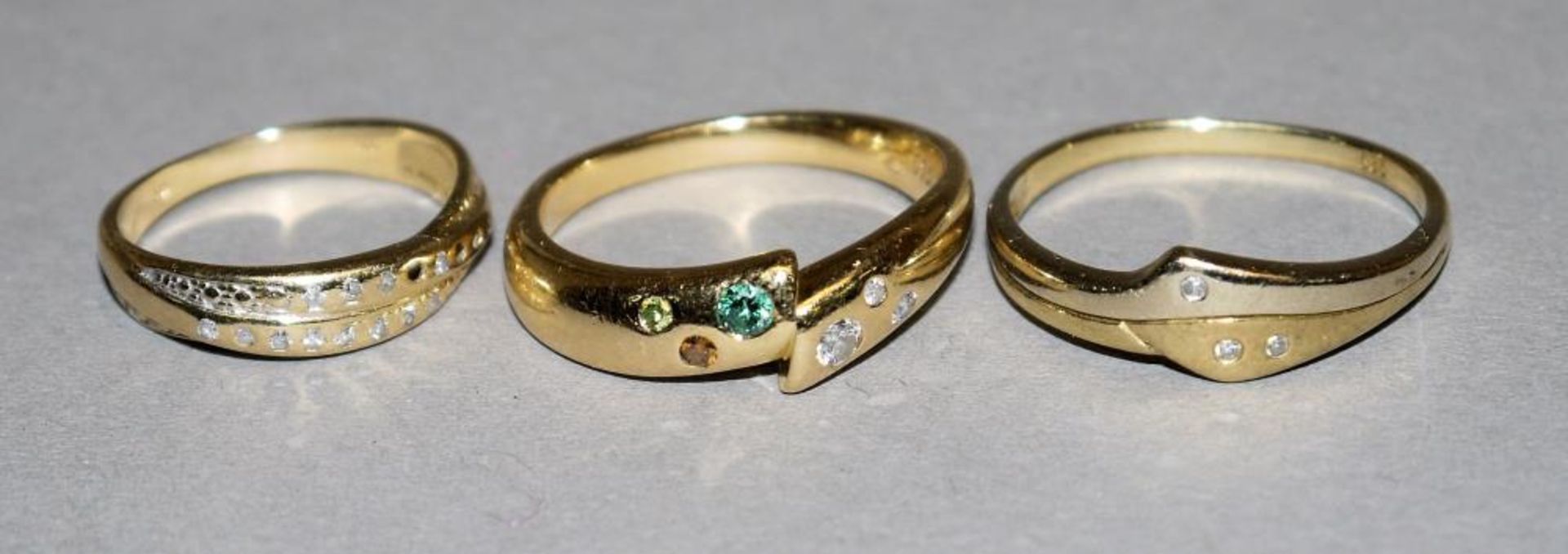 Drei Goldringe mit Steinbesatz Sog. Schlangenring, 18kt Gelbgold, besetzt mit 3 Brillanten,