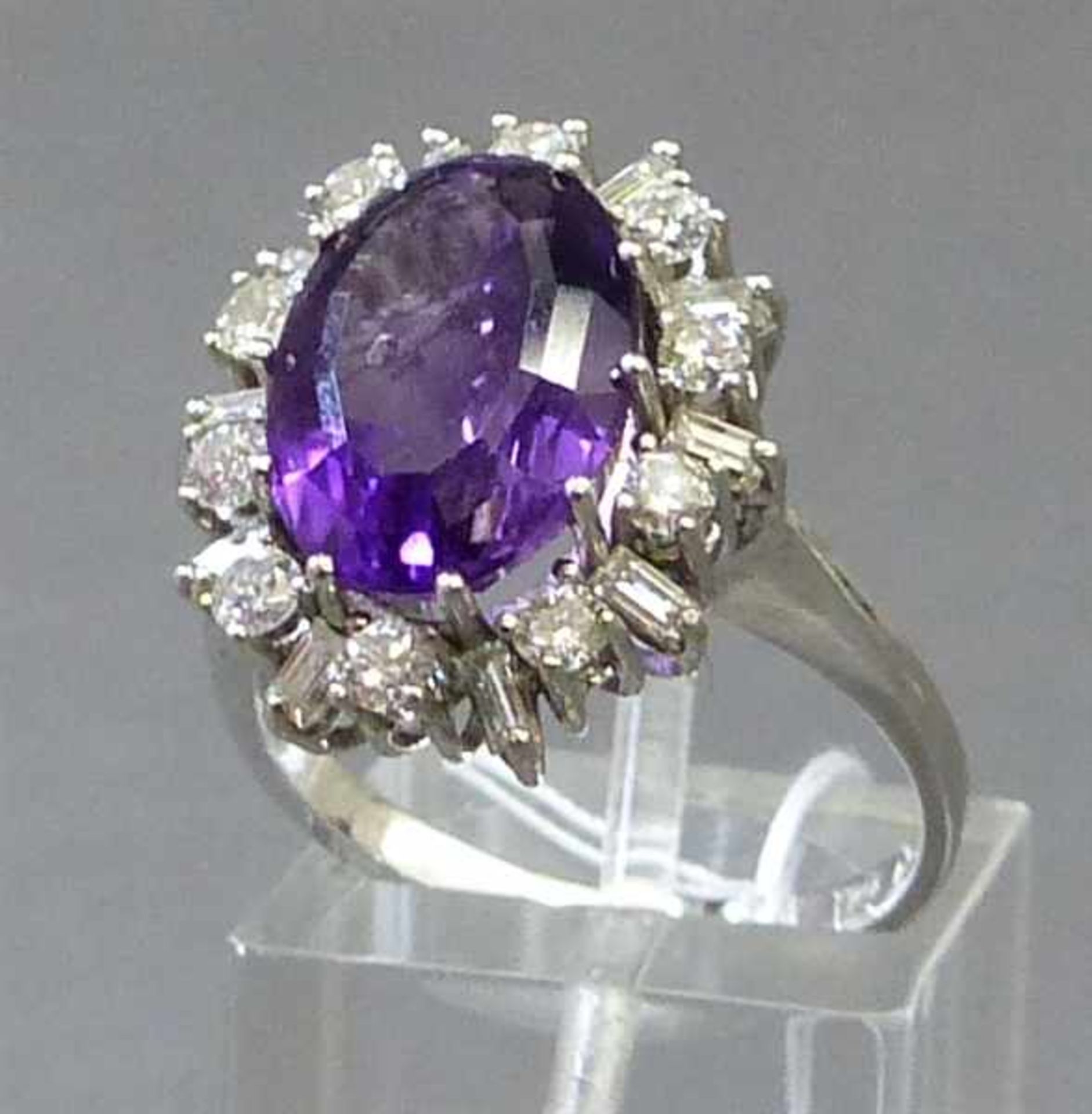 Damenring18 kt. Weißgold, 1 ovaler Amethyst, Kranz mit 10 Brillanten und 10 Baguettediamanten zus.