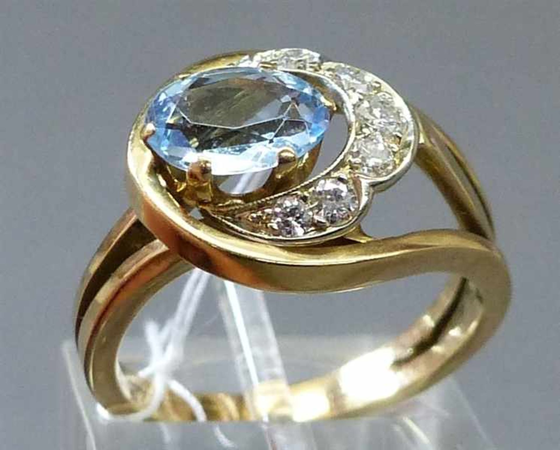 Damenring14 kt. Gelbgold, 1 ovaler Aquamarin, besetzt mit 7 Brillanten zusammen ca 0,25 ct.,