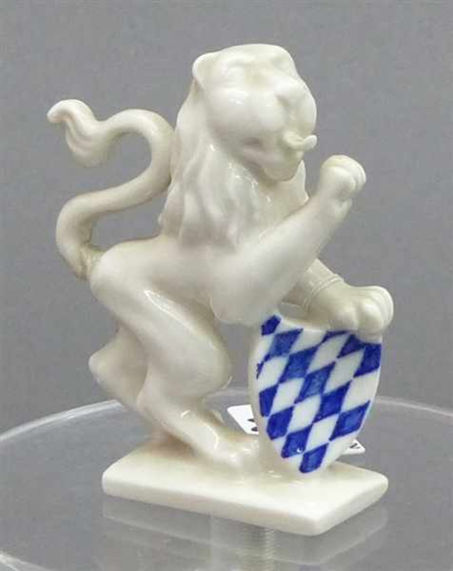 PorzellanskulpturBayerischer Löwe mit blau-weißem Wappenschild, Schwanz geklebt, Blindpräge-Raute,