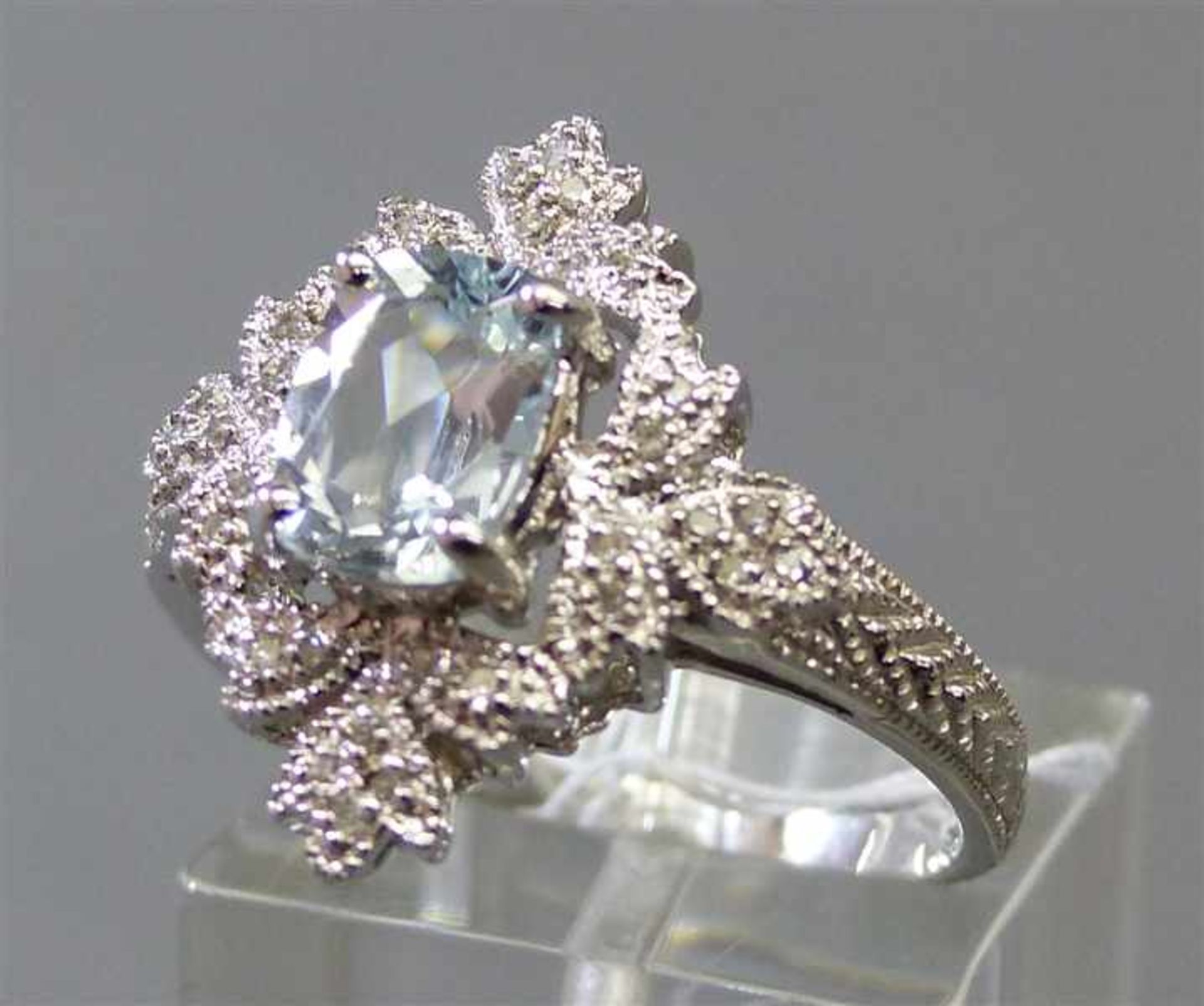 Damenring14 kt. Weißgold, 1 Aquamarin, Diamantbesatz, durchbrochen gearbeitet, ca 5gm, RM 60,