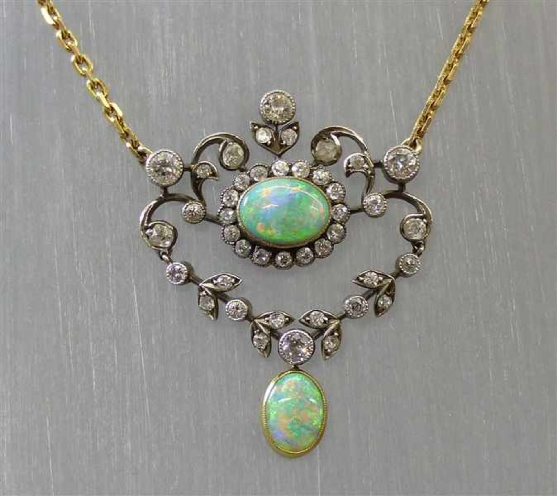 Opalcollier, um 190014 kt. Gelbgold und Silber, 2 ovale Opale, 4 Altschliffdiamanten zusammen ca 0,