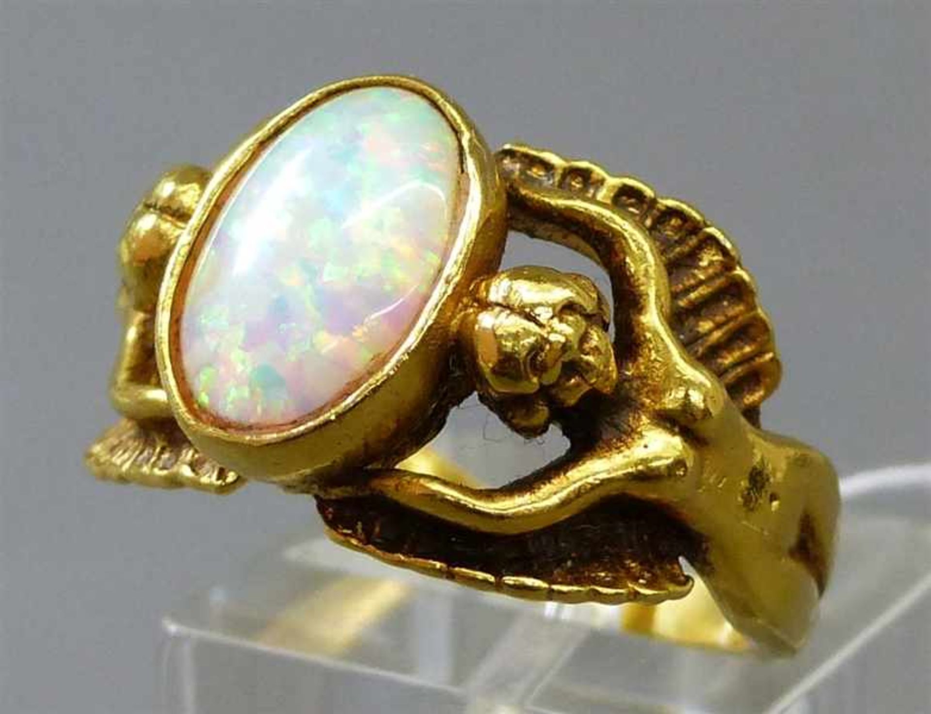 Damenring9 kt. Gelbgold, 1 ovaler Opal, durchbrochen gearbeitete Fassung, geflügelte Fabelwesen,