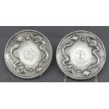 Paar MünztellerchenChina, Silber, Drachendekor, Reliefarbeit, 2 chinesische Münzen, rund, ca. 130