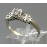 Damenring14 kt. Weißgold, 1 Brillant ca 0,14 ct., getöntes weiß, pique, 10 kleine Diamantrosen als