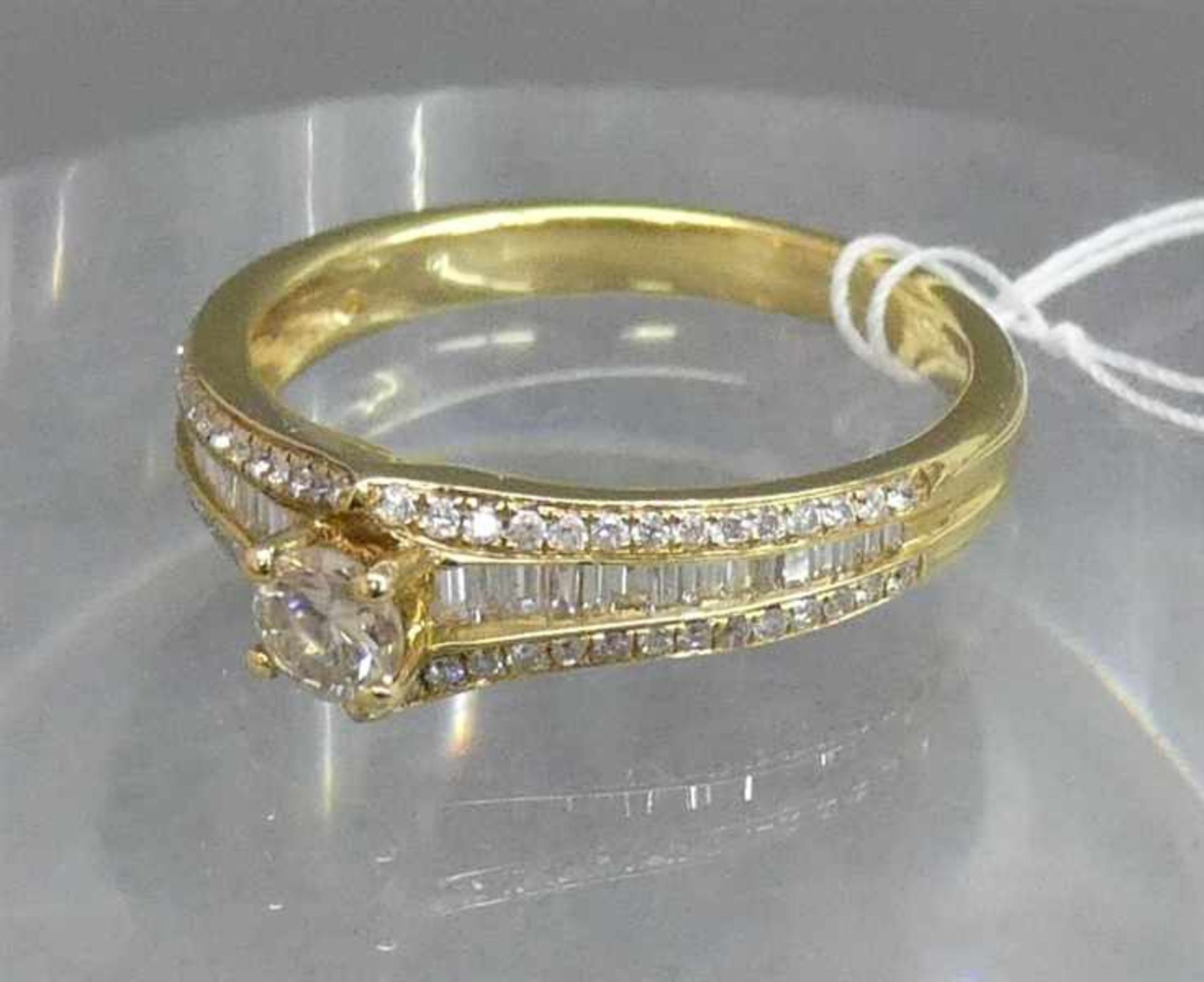 Damenring18 kt. Gelbgold, 1 Brillant 0,25 ct., weiß, vs, 56 Brillanten und 30 Diamantbaguetten 0,