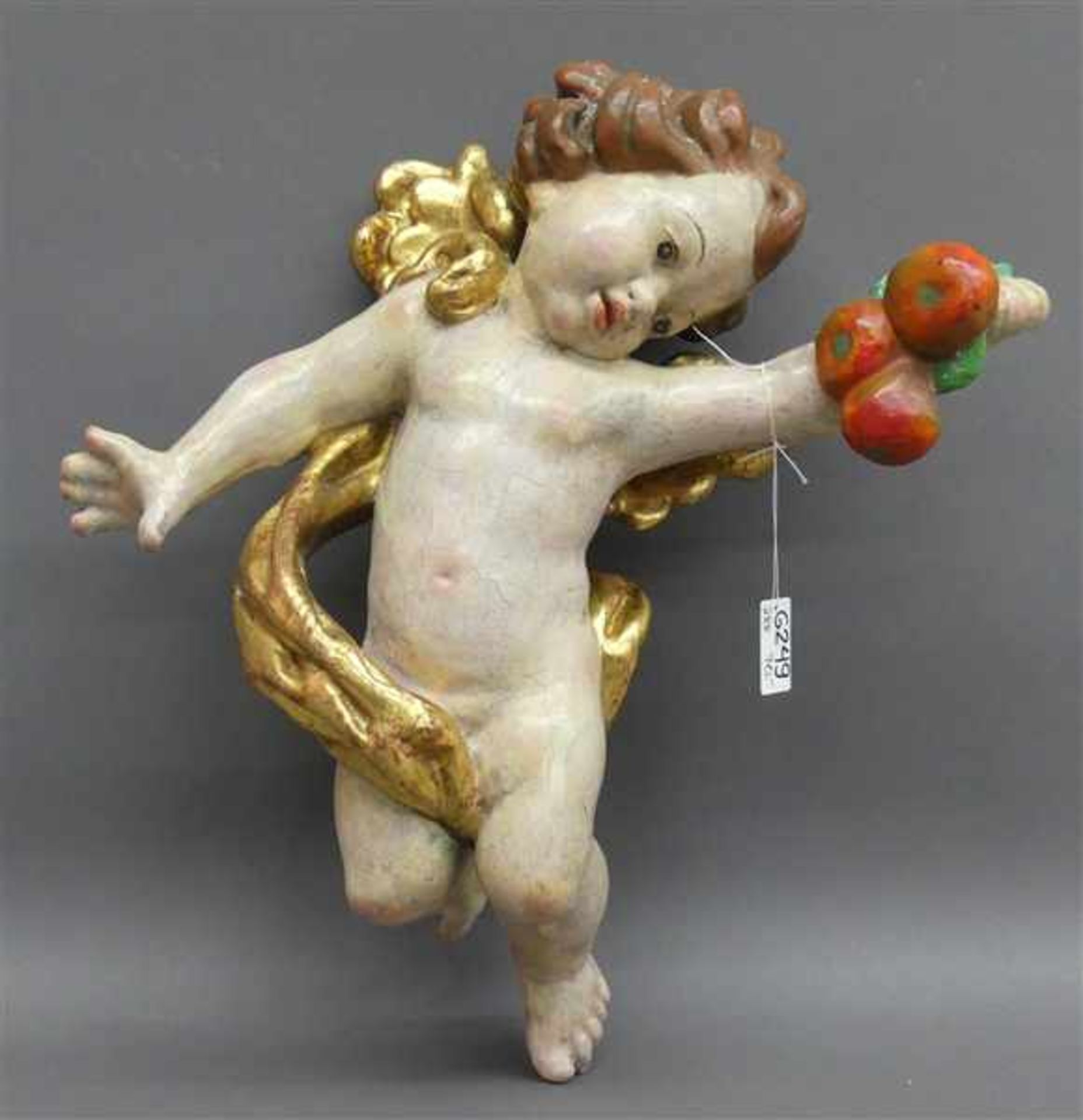 Schnitzarbeit Holz, gefasst, "Putti mit Äpfeln", teilvergoldet, Grödnertal, 20. Jh., h 33 cm,- - -