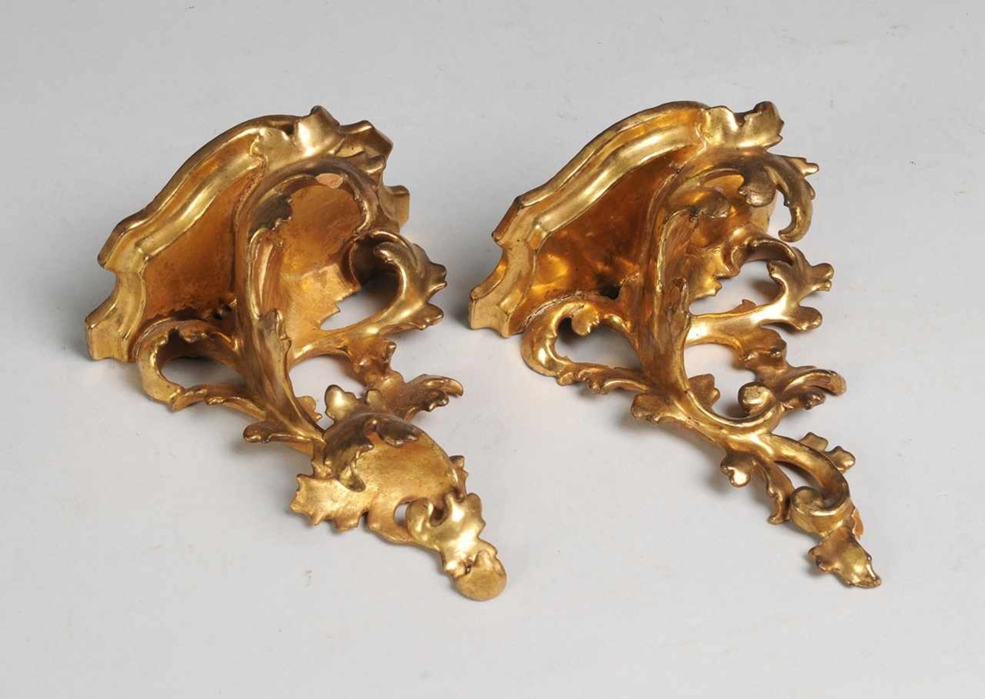 Paar Rokoko-KonsolenHolz, vergoldet. Von Akanthus-Schnitzwerk getragene, geschweifte Platten. Rücks.