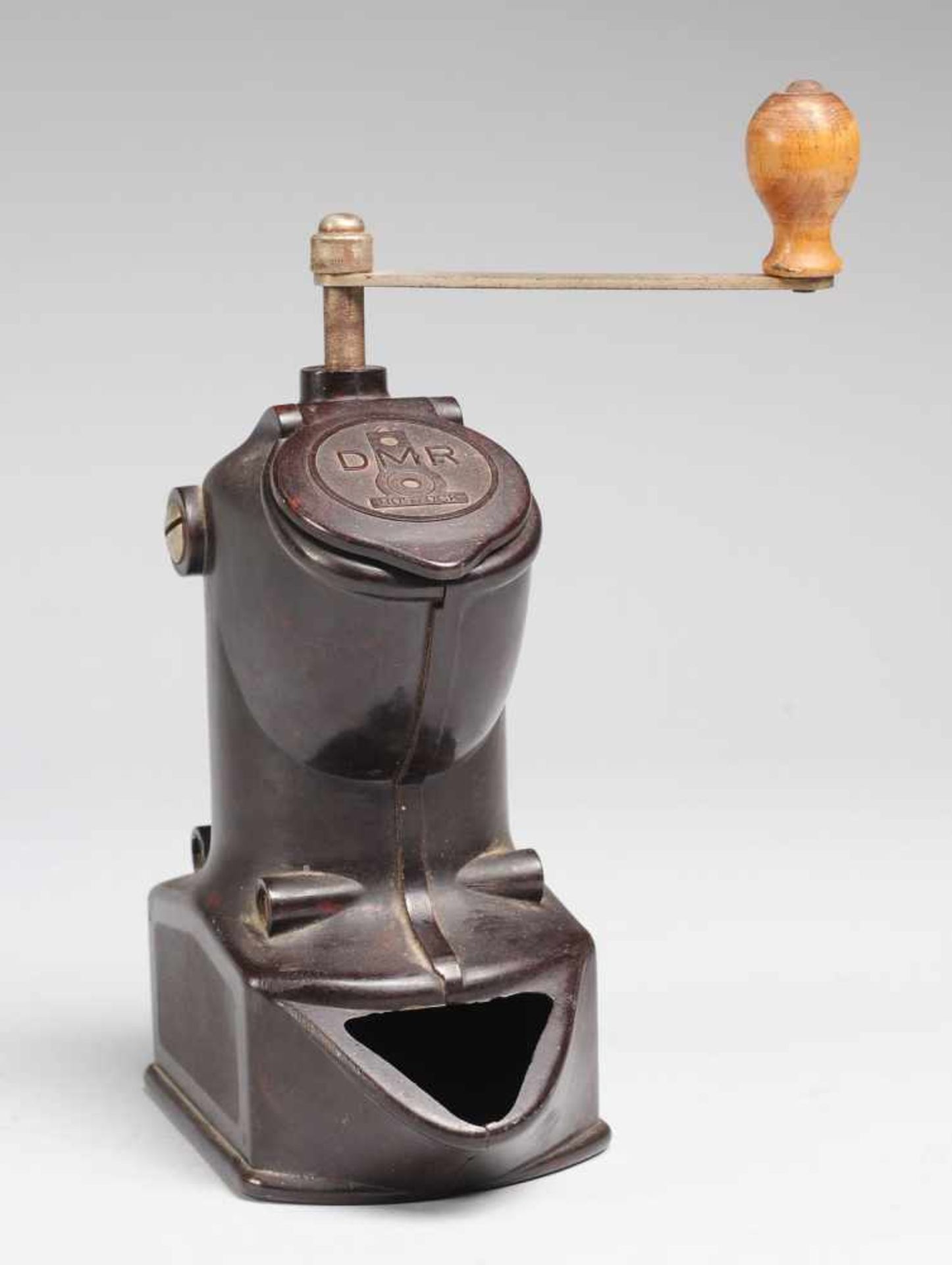 Bakelit-KaffeemühleVerschraubtes Gehäuse mit gefederter Klappe. Kurbelarm aus vernickeltem Stahl mit
