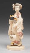 OkimonoElfenbein. Auf ovalem Sockel stehende Darstellung einer Geisha, ein Kästchen in der Hand u.
