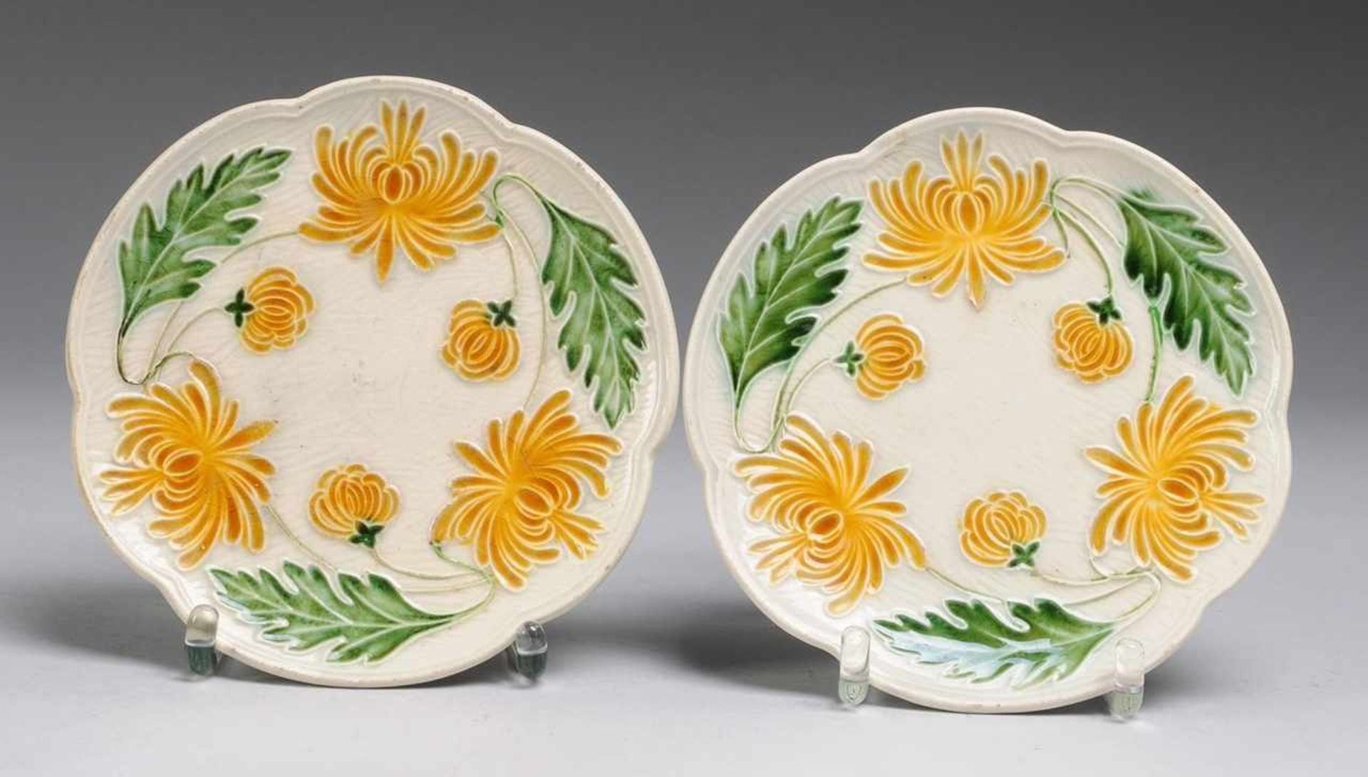 Paar Jugendstil-Zierteller mit ChrysanthemendekorSteingut, grau glasiert. Flache Form mit