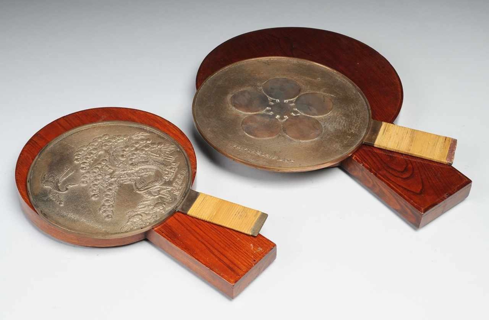 Paar Bronze-Handspiegel im HolzetuiPatiniert. Sogen. e-kagami. Runde Form, länglicher Griff mit