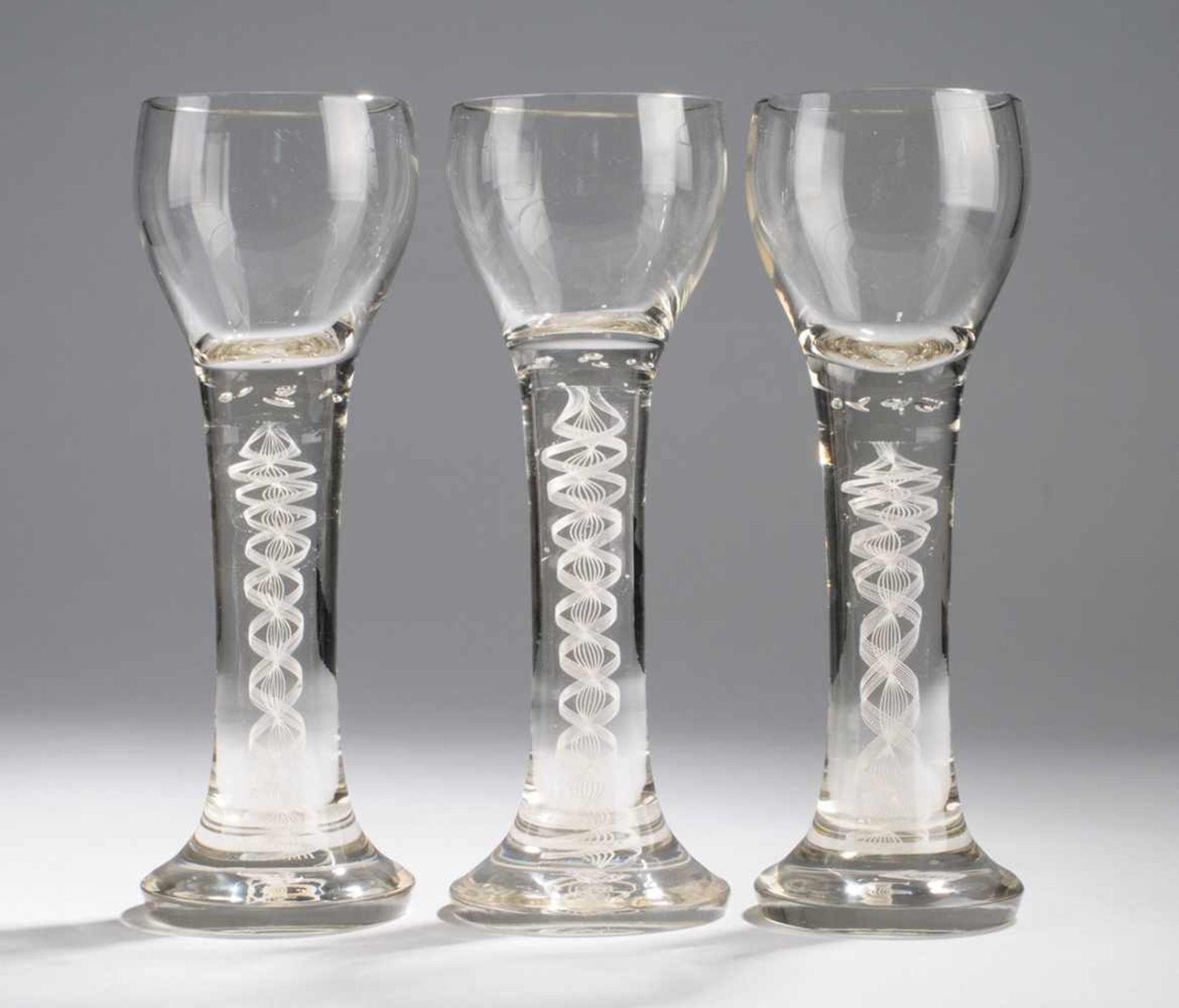 Drei Fadenglas-RömerFarbloses Kristallglas. Formgeblasen. Ansteigender Fuß, in kräftigen Schaft