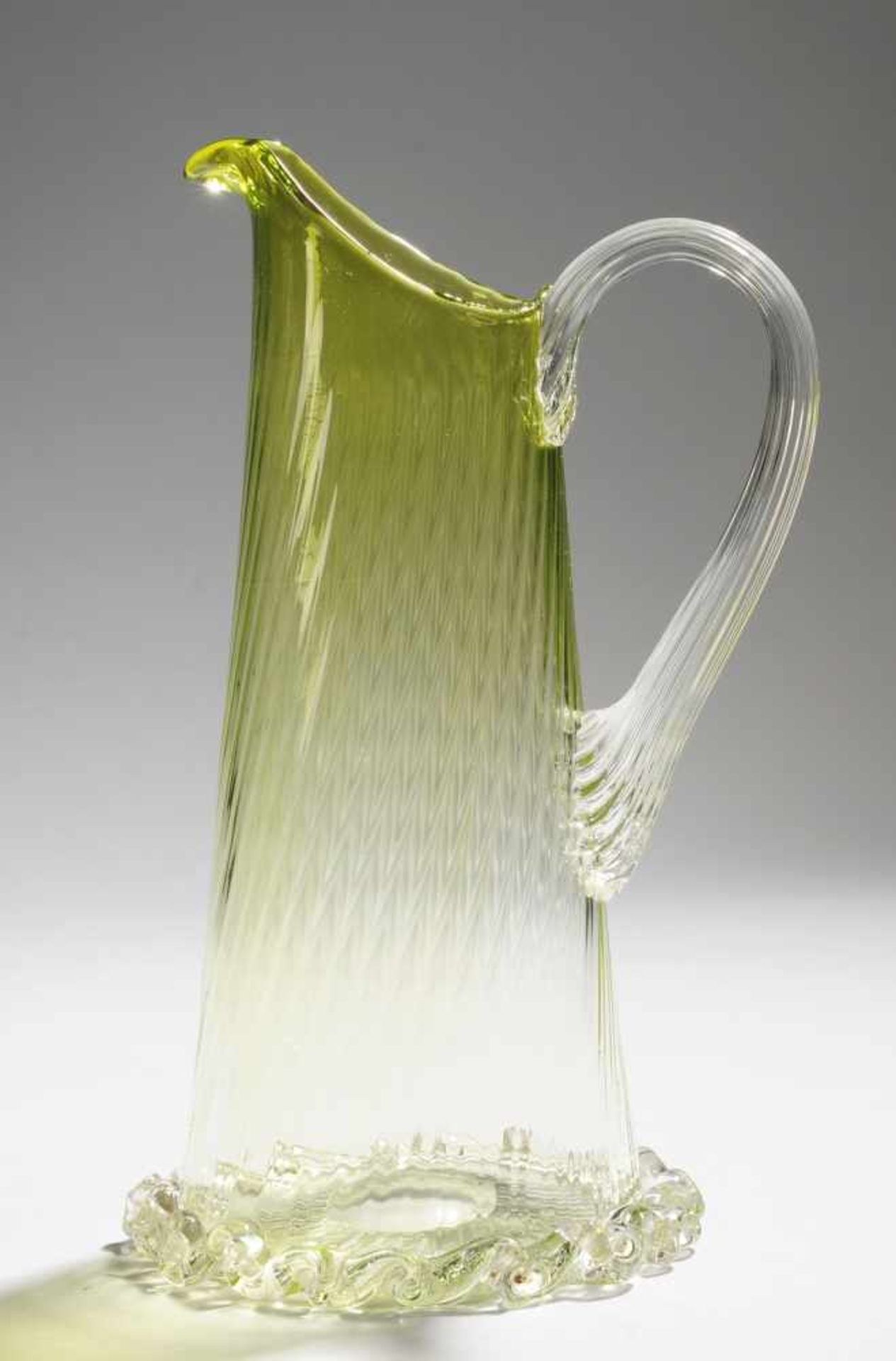 Kleiner HenkelkrugFarbloses u. grünes Glas. Optisch gerippt formgeblasen, ausgekugelter Abriss.