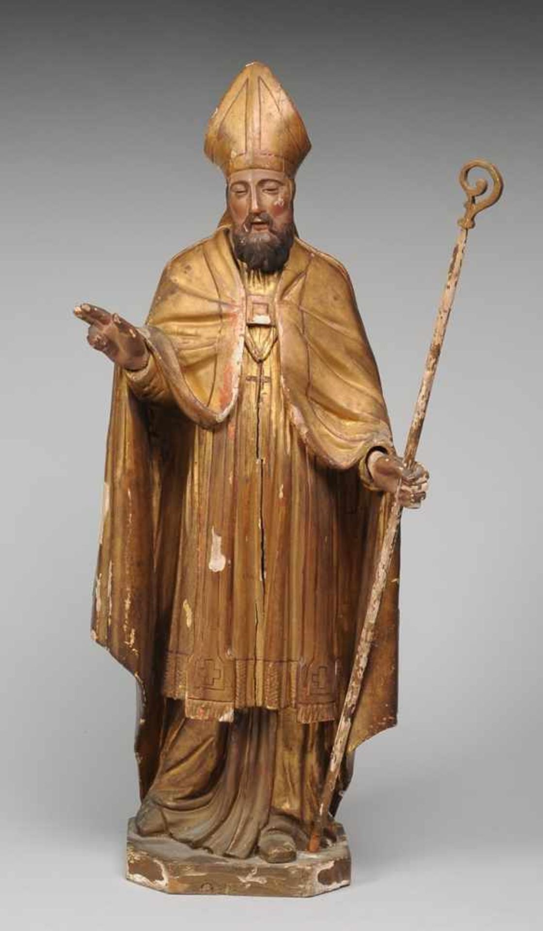 Figur eines Heiligen BischofsHolz, geschnitzt, farbig u. golden gefasst. Auf polygonalem Sockel