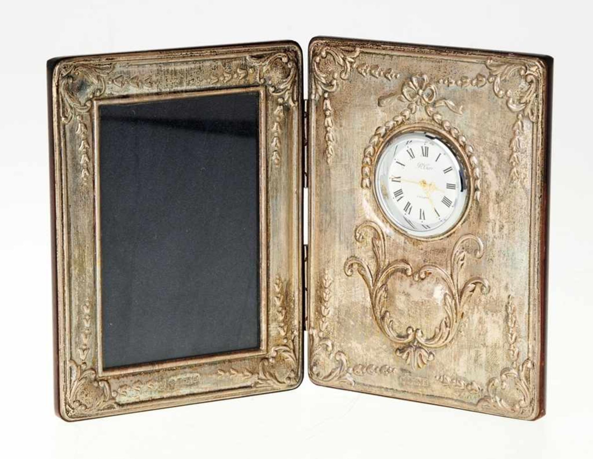 Tischrahmen mit UhrScharnierte Holzflügel mit Photorahmen u. Uhr, schaus. mit floral reliefiertem